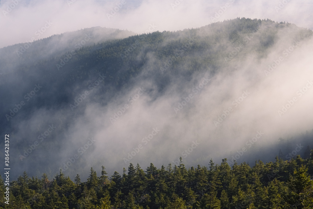 Morning fog over the ridge leading to the top of Mount Monadnock on an autumn morning in Jaffrey New Hampshire