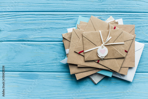 Top view of wooden blue background with envelopes and heart photo