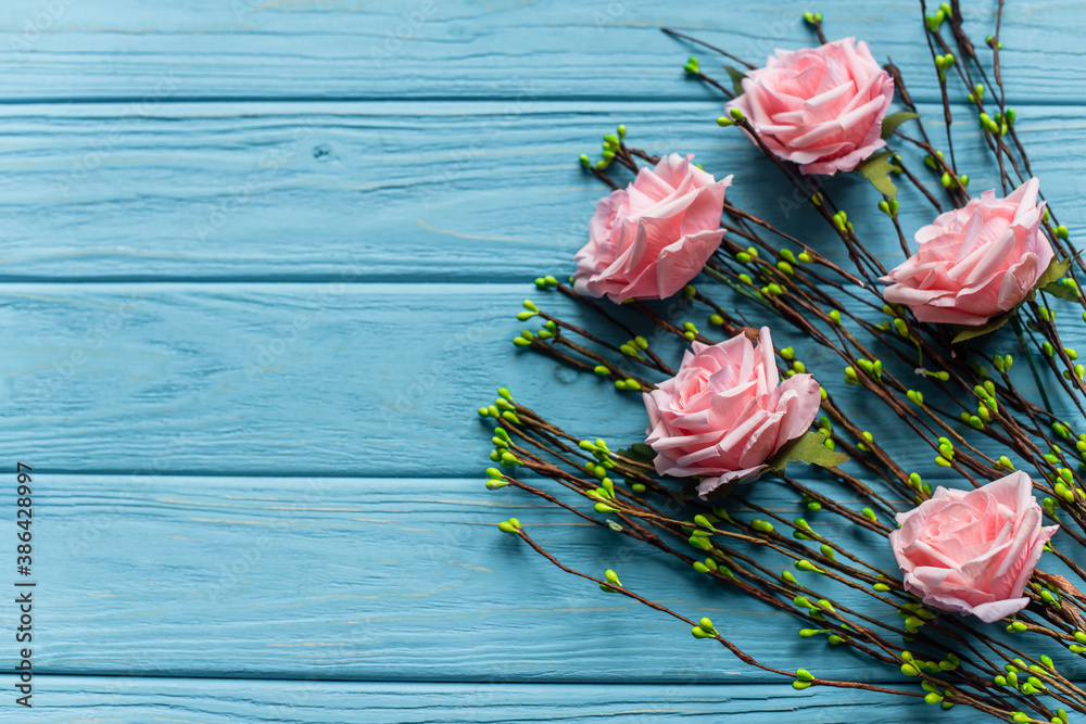 Wooden blue background with blossoming branches and roses