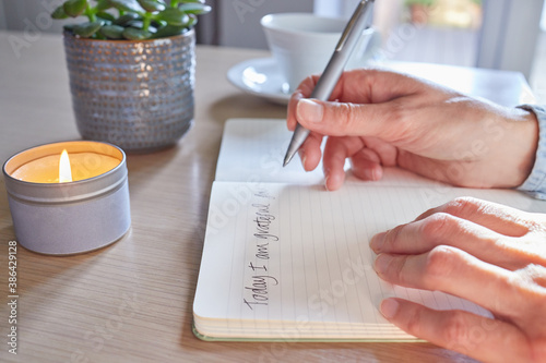 Картината върху платно Close Up Of Woman At Home Writing In Gratitude Journal