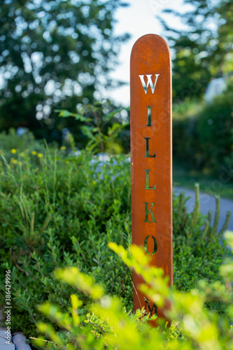 Willkommen Schild zwischen Büschen