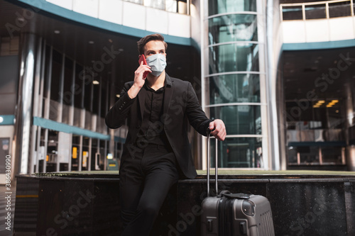 Man talking on phone while waiting for his flight photo