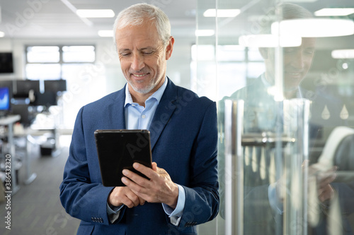Senior businessman using digital tablet at modern office