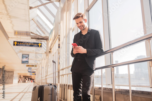 Man texting with his friends while waiting for a flight