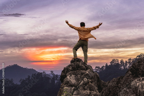Tablou pe pânză Success male hiker with arms outstretched on top of mountain