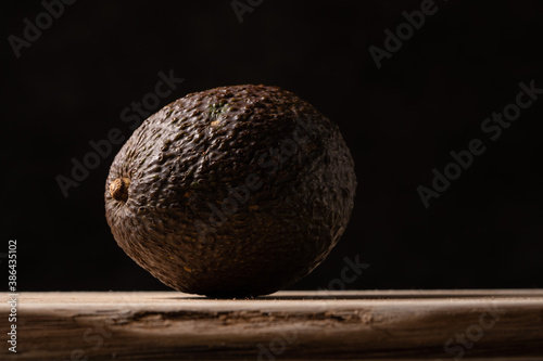Fresh avocado on wooden board on black background. High quality photo