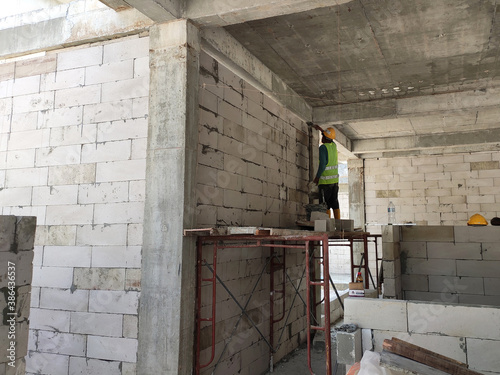 SEREMBAN, MALAYSIA -MARCH 16, 2020: Construction workers laying autoclaved aerated concrete block at the construction site. The use of this material can save time and facilitate construction work. photo