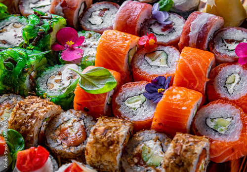 set of sushi roll with salmon, avocado, cream cheese, cucumber, rice, caviar, eel, tuna on wooden table