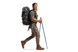 Full length profile shot of a bearded guy hiker with a backpack and hiking poles walking
