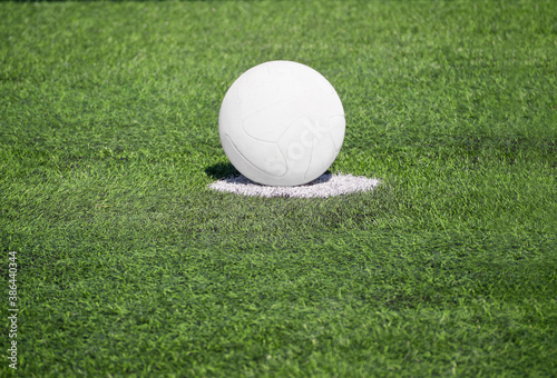 White soccer ball on green turf grass of football pitch
