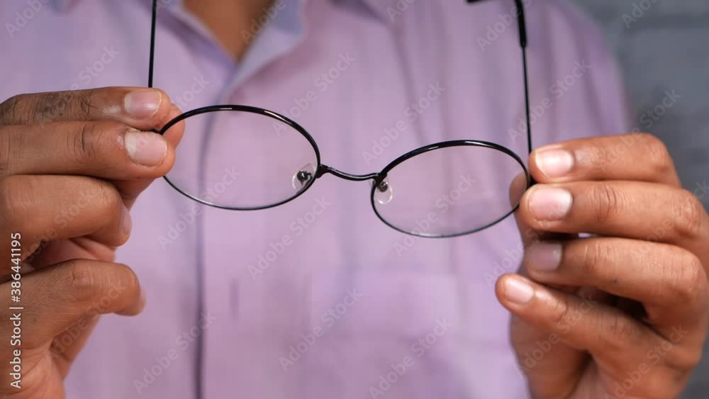 Close up of man hand holding eyeglass in dark. Close up of man hand holding eyeglass in dark.