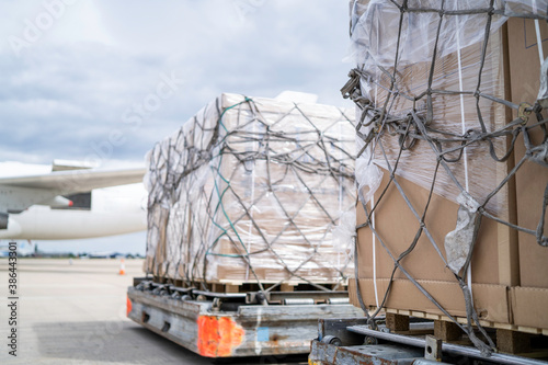 air freight cargo on dolly trailer waiting to be loaded onto aircraft photo