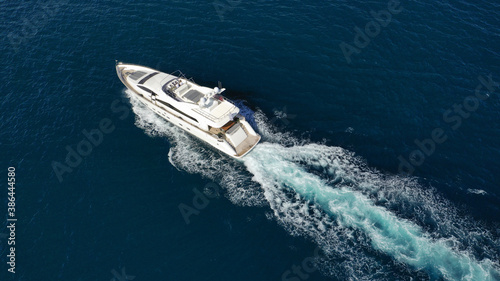Aerial drone photo of luxury yacht with wooden deck cruising deep blue Aegean sea near island of Mykonos, Cyclades, Greece © aerial-drone