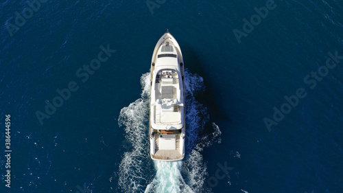 Aerial drone photo of luxury yacht with wooden deck cruising deep blue Aegean sea near island of Mykonos, Cyclades, Greece © aerial-drone