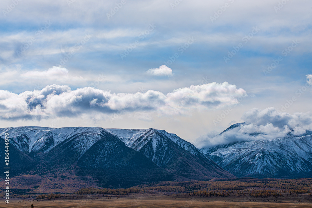 panoramic view of picturesque snowy mountains tops on blue sky background