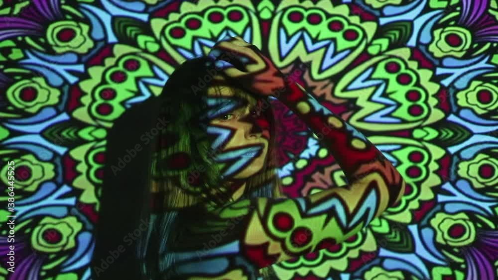 Portrait of girl close-up modern club party with dynamic projector multicolor light illumination. Colorful patterns of light in form of mandala projected onto face of attractive woman Portrait of girl close-up modern club party with dynamic projector multicolor light illumination. Colorful patterns of light in form of mandala projected onto face of attractive woman