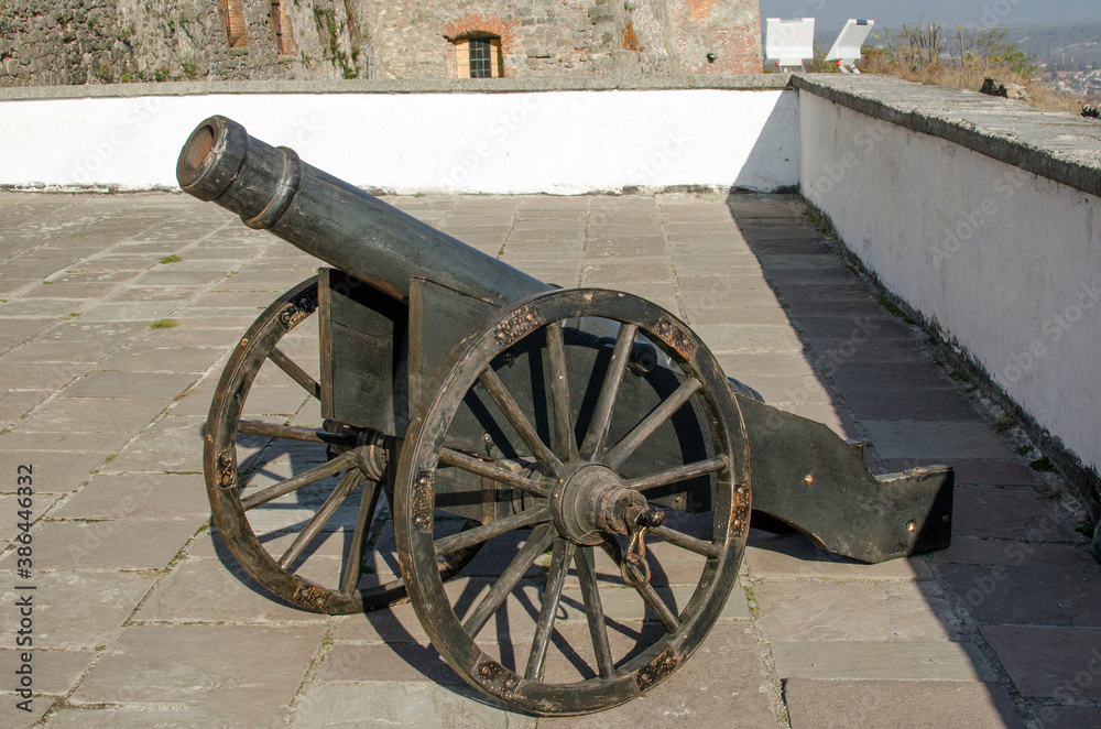 Old metal cannon on the wall of the fortress.