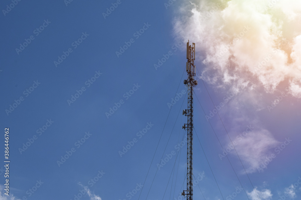 Phone transmitter antena. Blue sky with telephone tower. Communication Tower with antenna and satellite dish telecom network on blue sky background Phone transmitter antena. Blue sky with telephone tower. Communication Tower with antenna and satellite dish telecom network on blue sky background