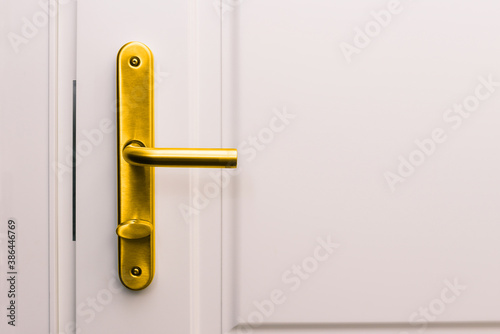 White door and golden handle. Entrance to a house, apartment, office or bedroom. Detail of the interior