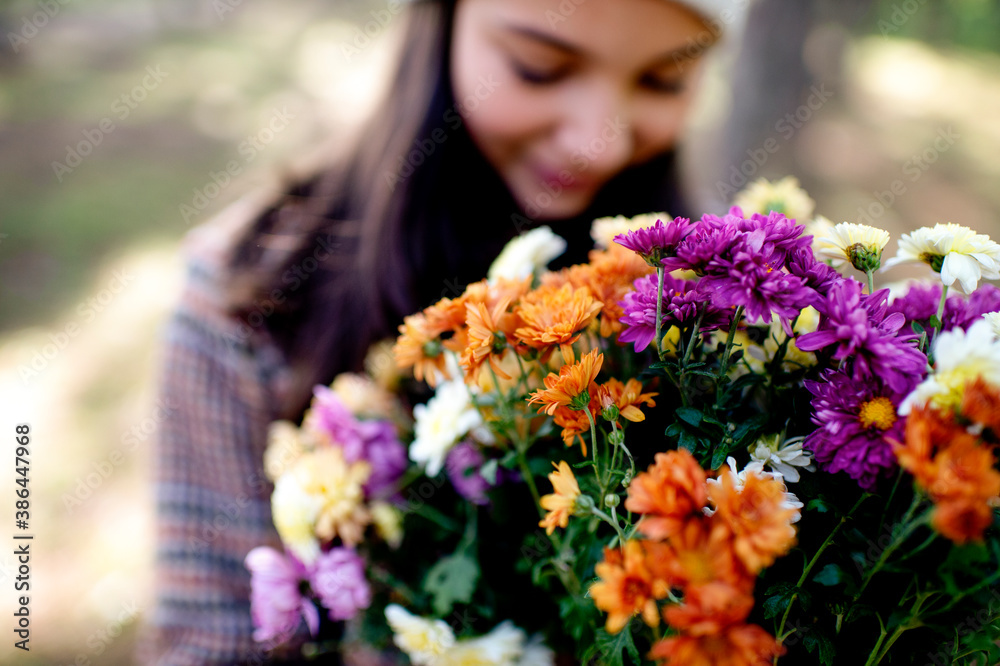 Fashionable teenage girl holding autumns flowers Fashionable teenage girl holding autumns flowers