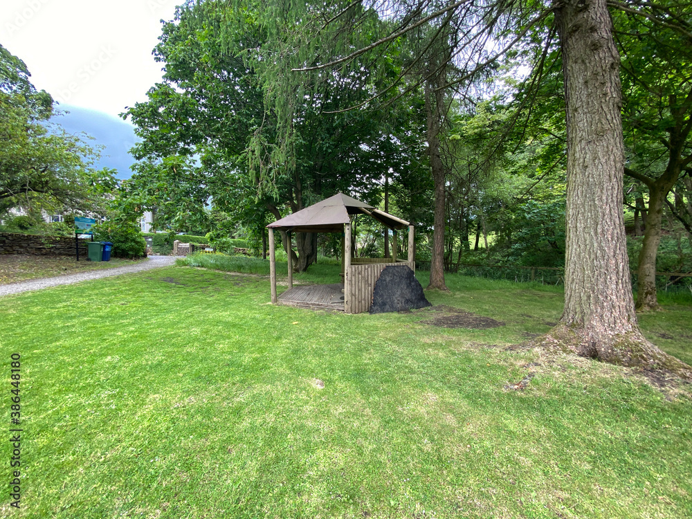 Small park area, with a wooden shelter, old trees, and footpath in the village of, Lothersdale, Keighley, UK
