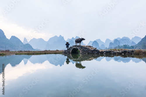 Chinese traditional living habits, traveling in Guilin, China, a farmer is plowing the land.