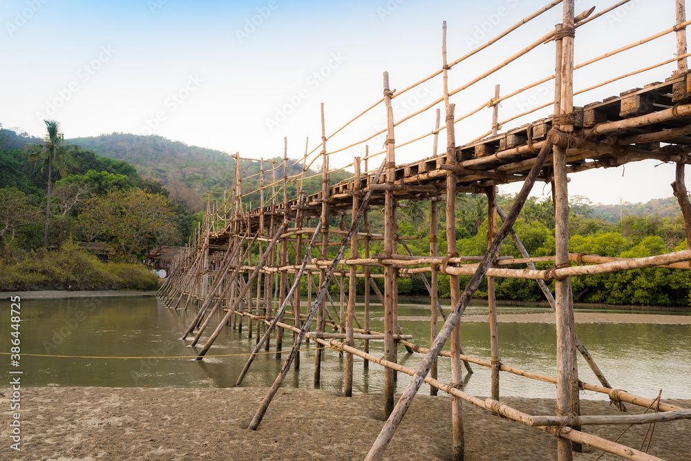 Wooden bridge with poles-props across the river in the jungles of India