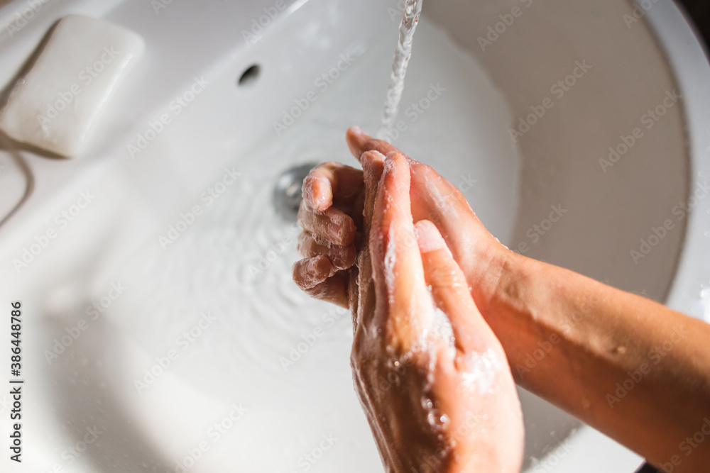 Fototapeta premium A woman washes her hands with soap.