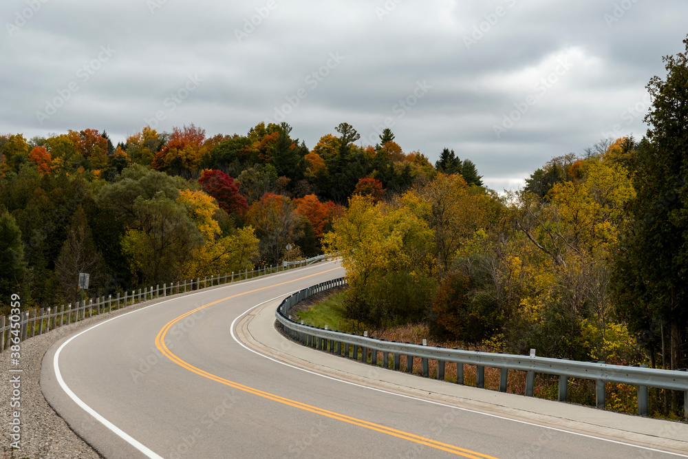 Autumn landscape - Road through bright orange and red trees. Autumn landscape - Road through bright orange and red trees.