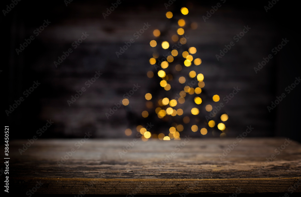 blurred background of xmas tree lights and wall wooden board and free place