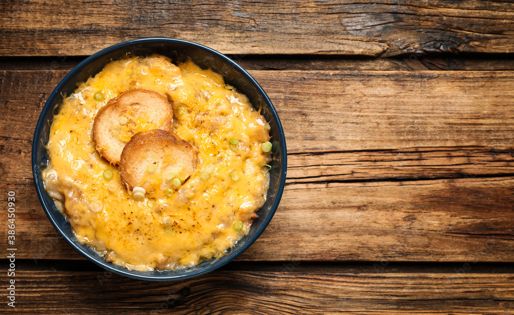 Tasty homemade French onion soup on wooden table, top view. Space for text Tasty homemade French onion soup on wooden table, top view. Space for text