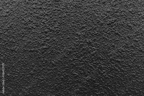 Rough patterned black cement wall texture and seamless background