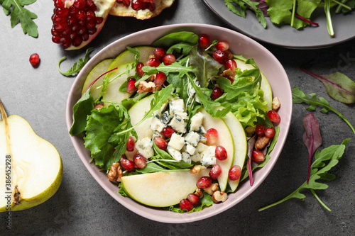 Tasty salad with pear slices and fresh ingredients on grey table, flat lay