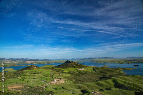Hills landscape with green fields and large reservoir