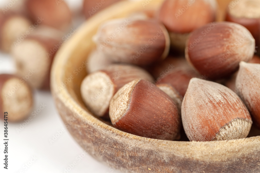 Big wooden spoon or plate with bunch of hazelnuts isolated on white background macro Big wooden spoon or plate with bunch of hazelnuts isolated on white background macro