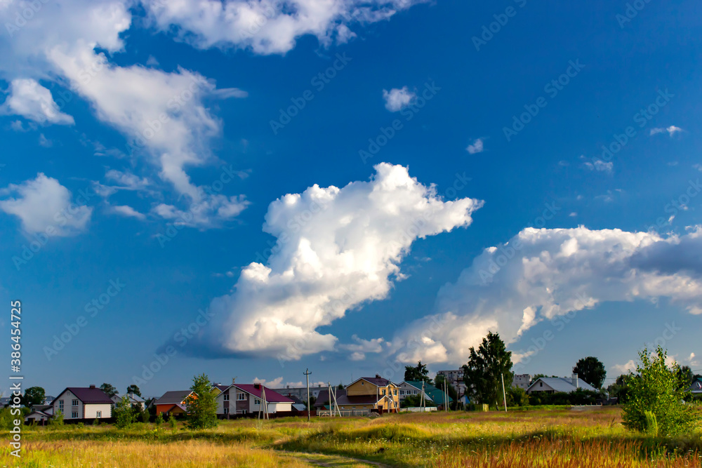 Russian rural landscape with white clouds in summer, village houses. Russian rural landscape with white clouds in summer, village houses.