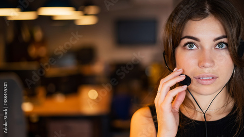 Portrait of a Caucasian woman wearing a headset with a microphone. Female hotline employee