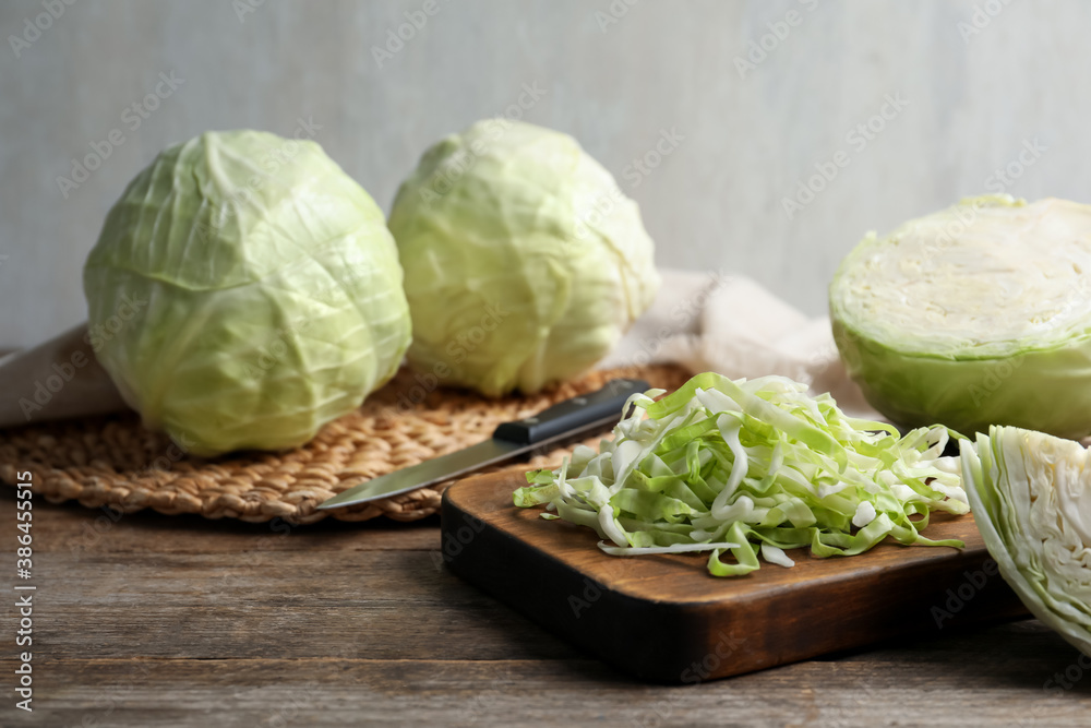 Whole and shredded cabbage on wooden table Whole and shredded cabbage on wooden table