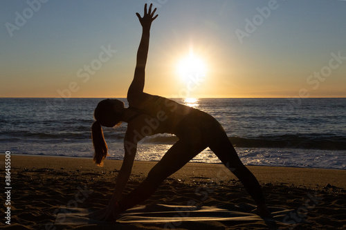 Caucasian woman doing stretching and yoga on Barceloneta beach in Barcelona
 photo