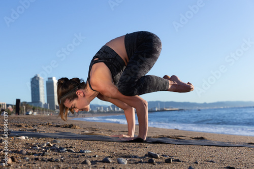 Caucasian woman doing stretching and yoga on Barceloneta beach in Barcelona
 photo