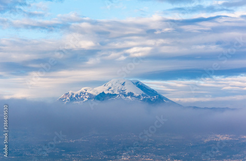 Chimborazo and Carihuayrazo volcanoes at sunrise with the city of Ambato