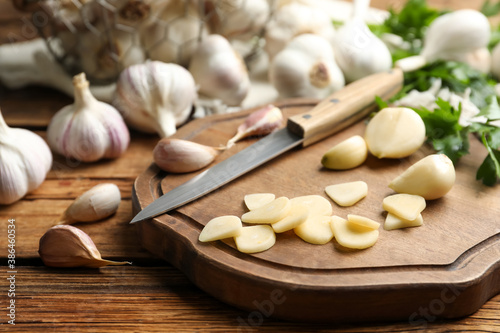 Fresh whole and cut garlic on wooden table. Organic product