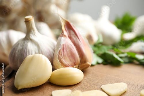 Fresh garlic bulb and cloves on wooden table, closeup. Organic product