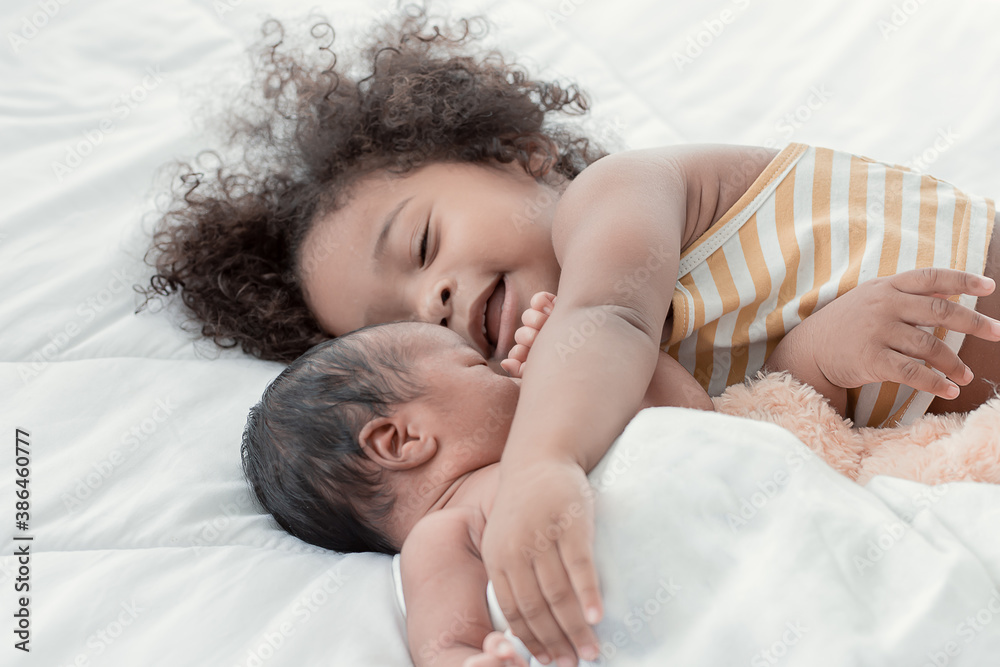 African girl hug her baby brother while sleeping on bed African girl hug her baby brother while sleeping on bed