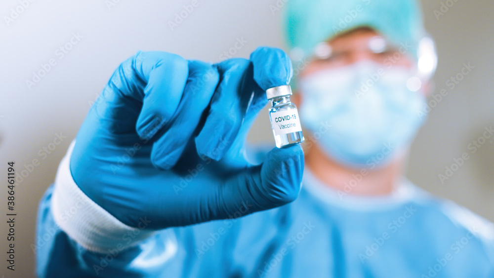 Virologist doctor with coronavirus vaccine in a medical vial. Close up Virologist doctor with coronavirus vaccine in a medical vial. Close up