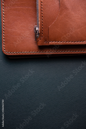 accessories made of brown leather lie on a black background close-up
