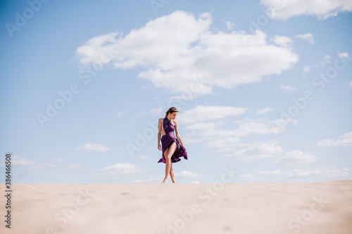 Wallpaper Mural A young, slender girl in a beige dress with purple cloth in her hands posing in the desert in the wind Torontodigital.ca