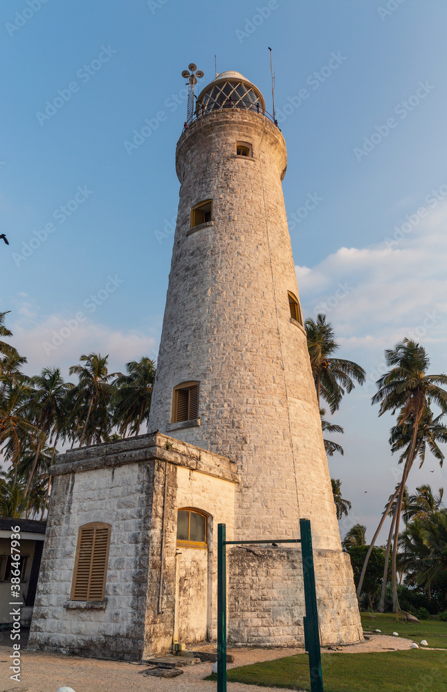 The old lighthouse of white stone located on the island
