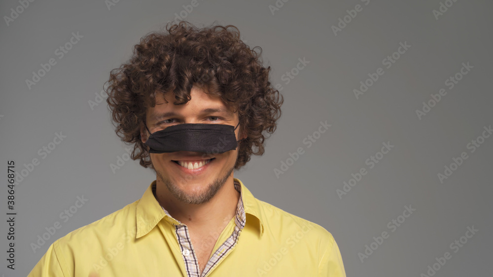 Obraz premium Funny man have fun wearing protective mask on his nose. Cut out on gray background. 