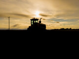 Tractor Silhouette in Field at Sunset in North Dakota.